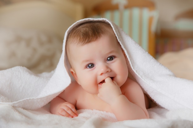 Photo bébé souriant heureux dans une serviette après le bain