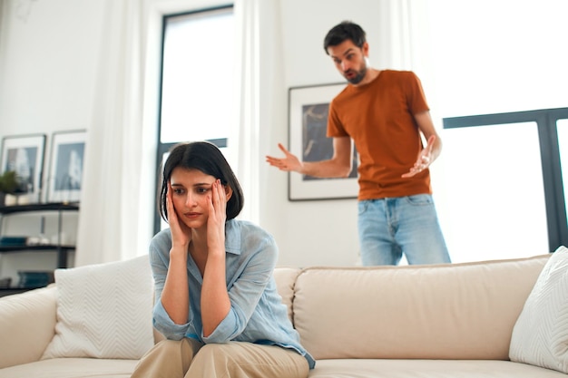 Photo d'une femme offensée assise dos à son amant regardant ailleurs en évitant de parler un couple millénaire ayant un combat sérieux un homme fou criant ou faisant la leçon à sa femme têtue femme pas prête à faire des compromis ou à se réconcilier